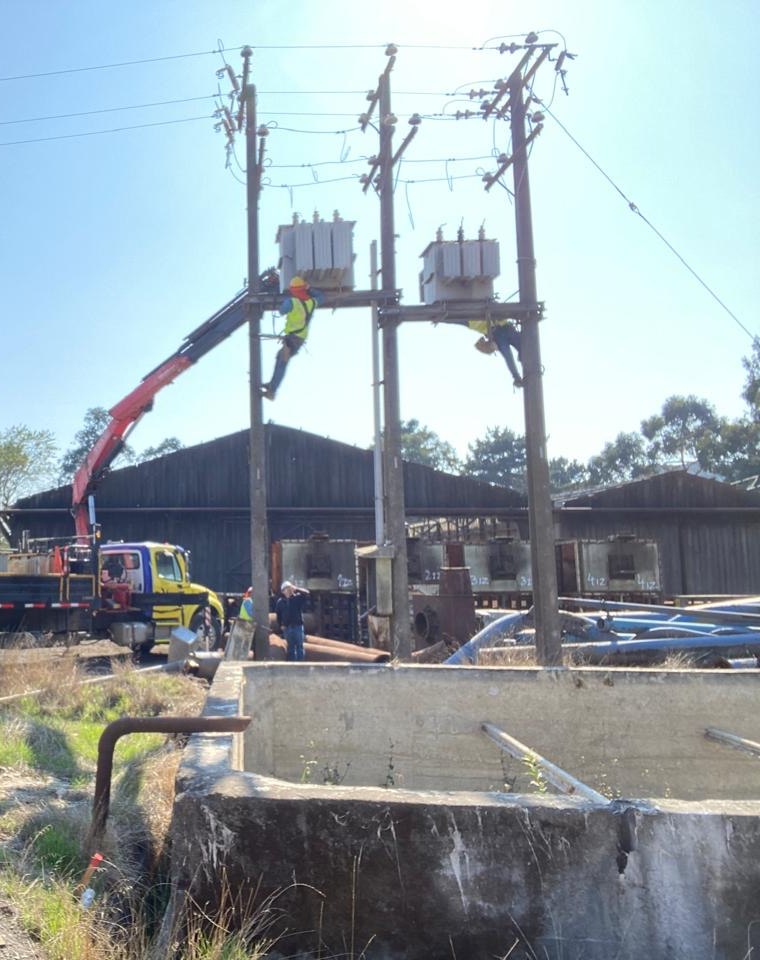 Cuadrilla de Redelectric montando transformadores en una línea de media tensión con camión pluma